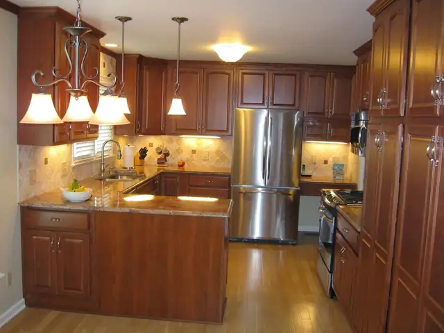 Cherry kitchen with granite counters and a light tile backsplash under the wall cabinets