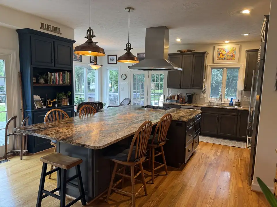 Kitchen with a large granite island, charcoal cabinets, navy hutch and copper pendant lights, kitchen and bath remodeling in Yorktown VA